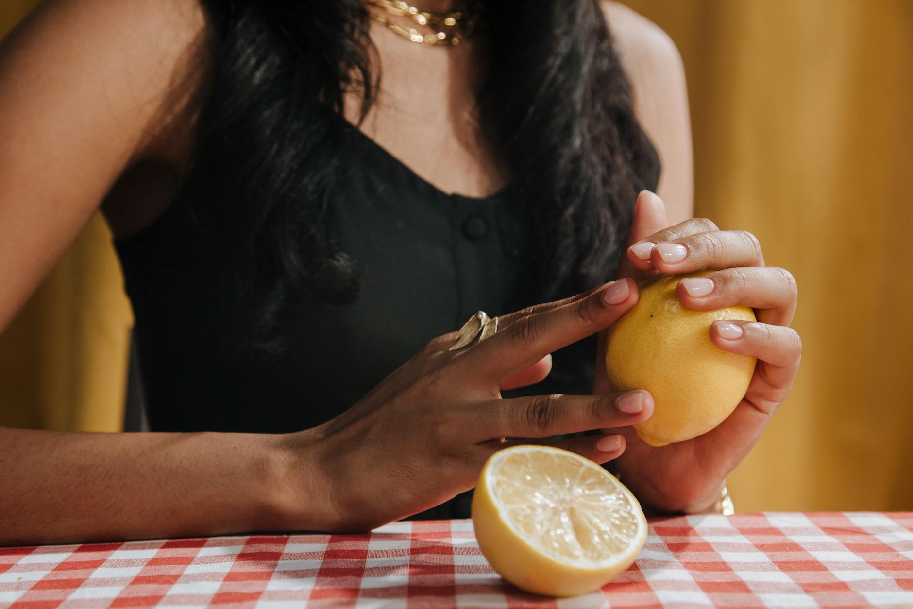 Close-up of hands holding fresh lemons, representing the gentle yet effective nature of lemon vibrator stimulation
