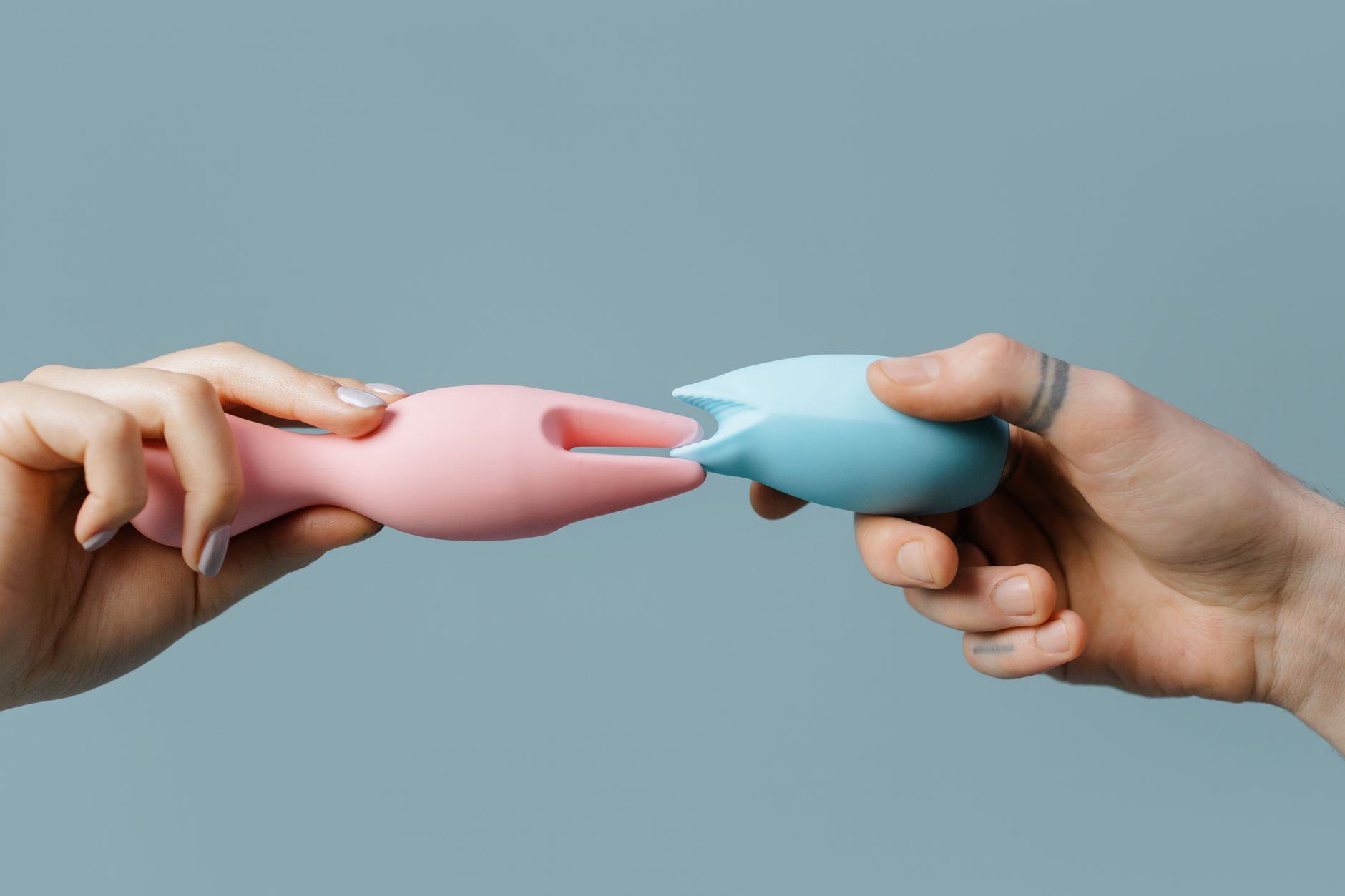 Hands holding pastel-colored silicone lemon vibrators