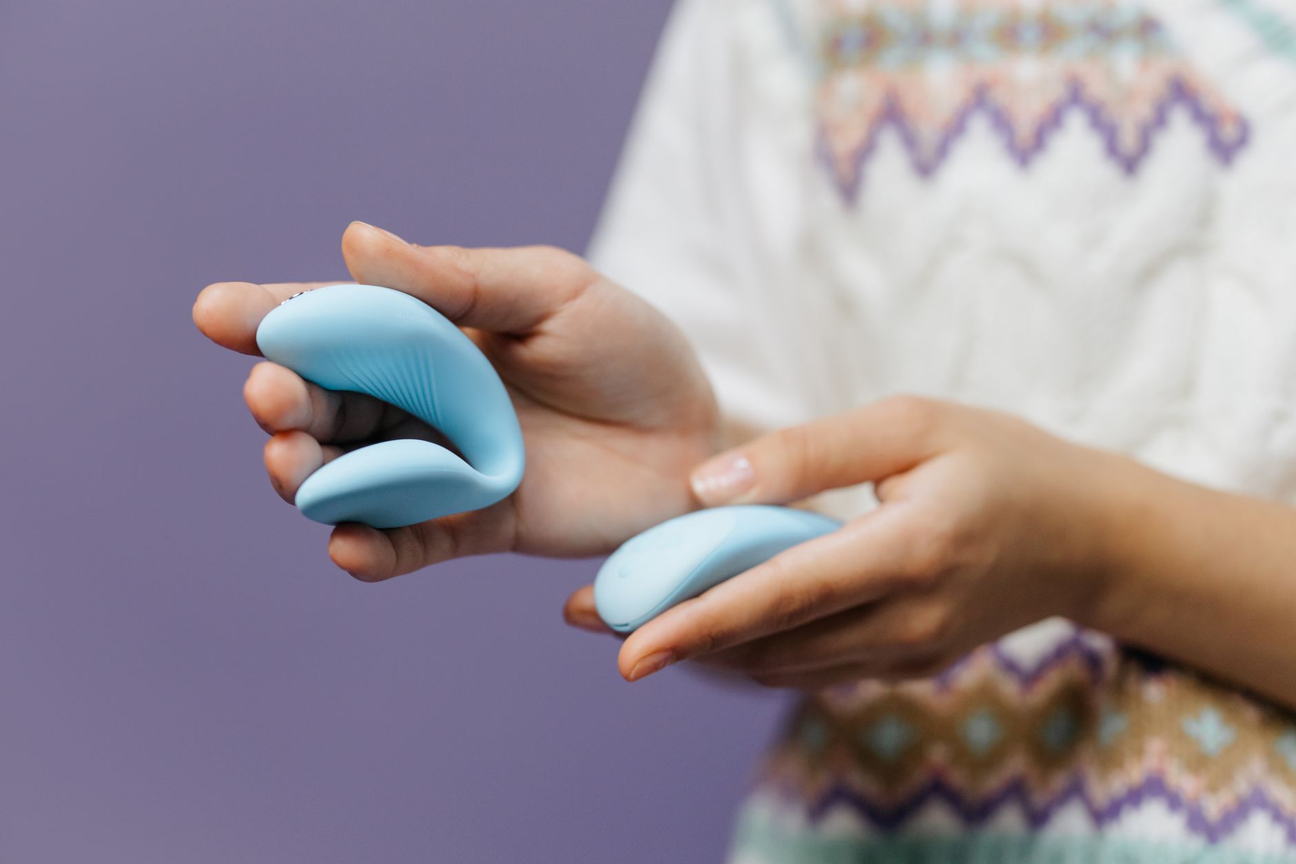 Hands holding a sleek blue lemon vibrator together, symbolizing shared intimacy and reconnection