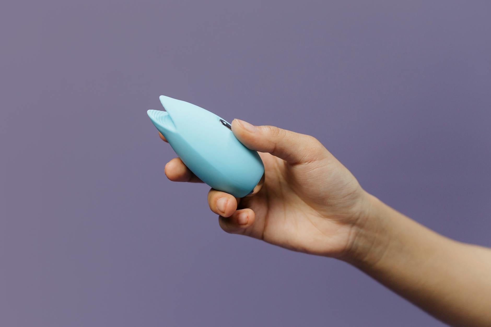 A silicone lemon clitoral vibrator held gently in hand, symbolizing self-directed pleasure and bodily autonomy